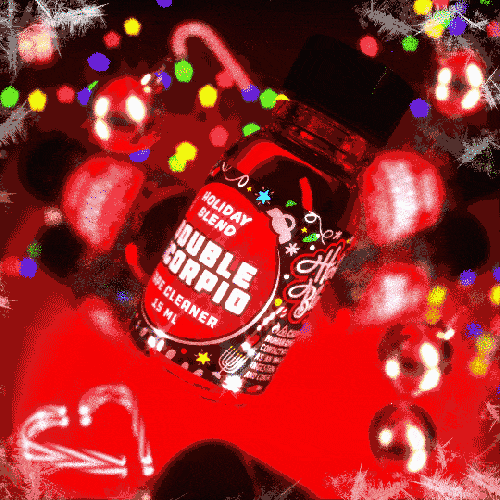A bottle of double scorpio holiday blend - 10ml cleaner levitating with a festive background of colorful, blurry lights adding a holiday vibe.